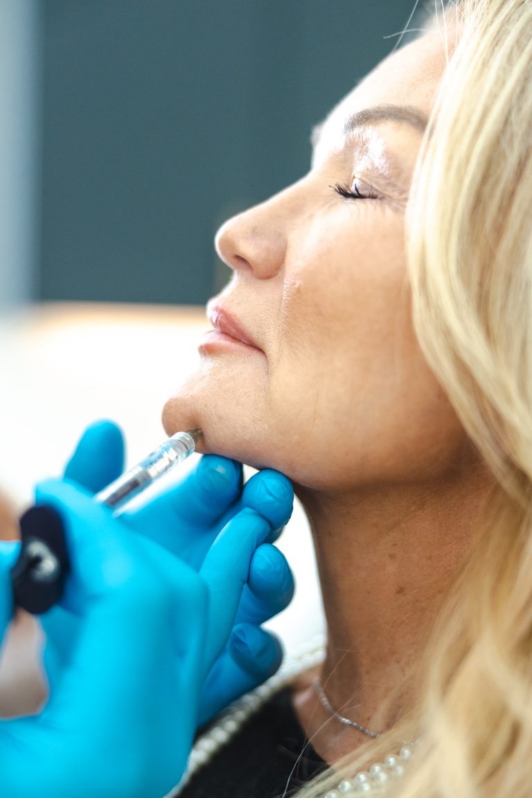 Female practitioner performing a rejuvenating treatment in a modern Lower Mainland clinic, focusing on enhancing mature skin.