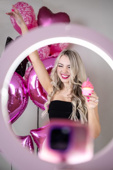 Female entrepreneur standing confidently in a colorful Vancouver studio, surrounded by props that highlight her unique brand aesthetic.