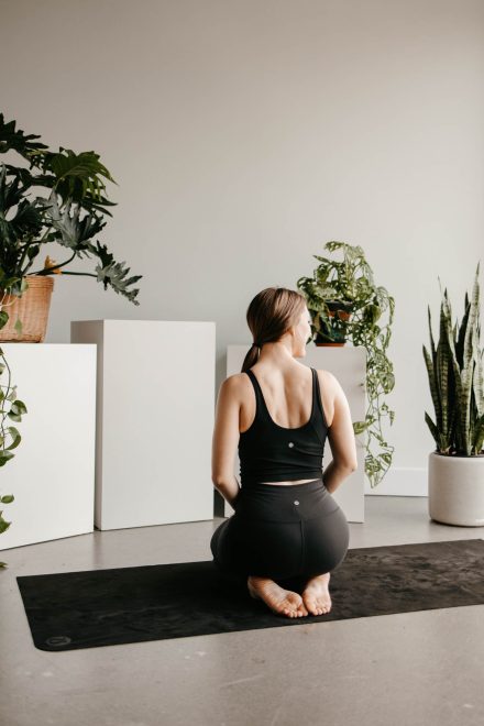 Yoga coach mid-flow in a bright Fraser Valley studio, capturing movement and energy in a peaceful setting.