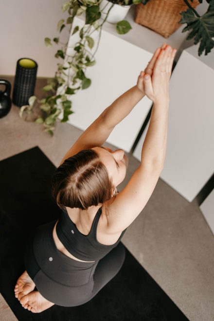 Yoga coach mid-flow in a bright Fraser Valley studio, capturing movement and energy in a peaceful setting.