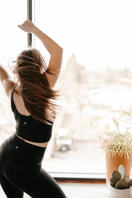 Yoga coach mid-flow in a bright Fraser Valley studio, capturing movement and energy in a peaceful setting.