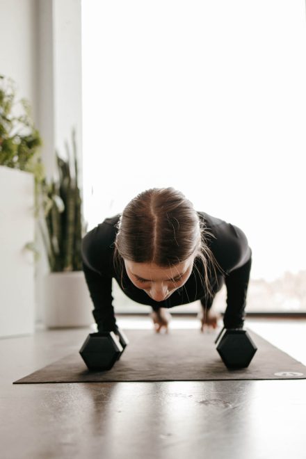 Yoga coach mid-flow in a bright Fraser Valley studio, capturing movement and energy in a peaceful setting.