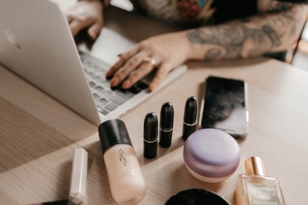 Luxurious makeup brushes and palettes styled on a soft pastel table in a Vancouver studio, highlighting elegance and attention to detail.