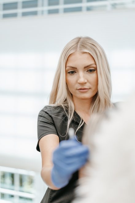 Female practitioner performing a rejuvenating treatment in a modern Lower Mainland clinic, focusing on enhancing mature skin.