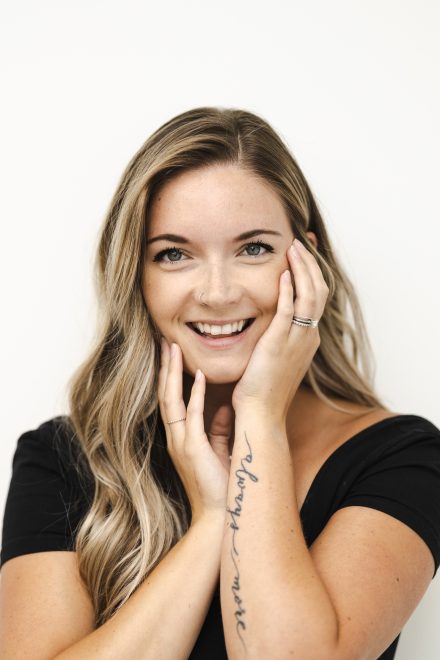 Confident female model posing in a bright Vancouver studio, showcasing radiant skin and effortless elegance.