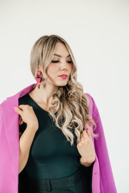 Female entrepreneur standing confidently in a colorful Vancouver studio, surrounded by props that highlight her unique brand aesthetic.