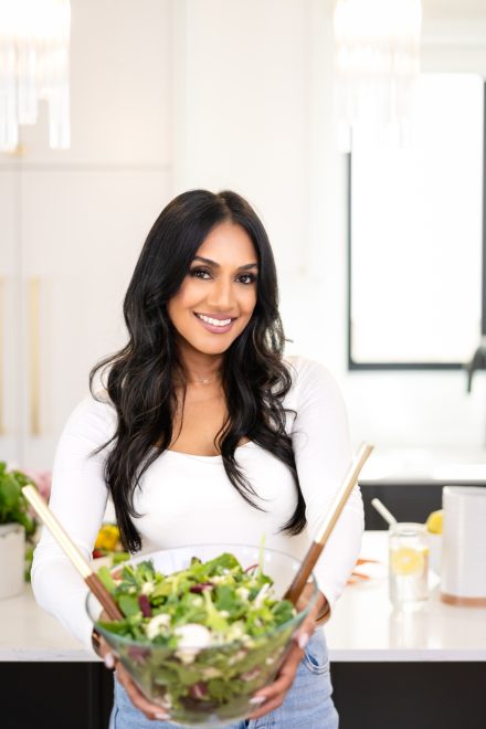 Confident dietitian standing in a well-lit kitchen in Fraser Valley, arms crossed, ready to guide clients on their wellness journey.