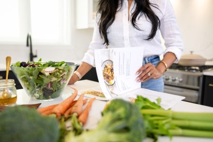 Nutrition coach setting up a workspace with fresh ingredients and educational materials in the Lower Mainland.