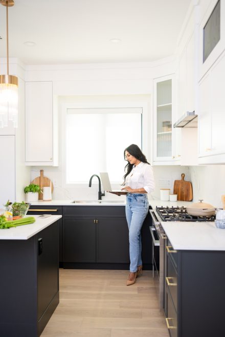 Confident dietitian standing in a well-lit kitchen in Fraser Valley, arms crossed, ready to guide clients on their wellness journey.