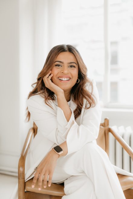 Female entrepreneur laughing during a casual conversation in a stylish co-working space in Langley.