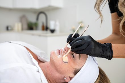 Skincare specialist applying an anti-aging facial mask on a client in a tranquil Vancouver med spa setting.