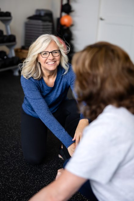 Personal trainer guiding a client through a workout in a cozy home gym setting in the Lower Mainland, emphasizing hands-on expertise.