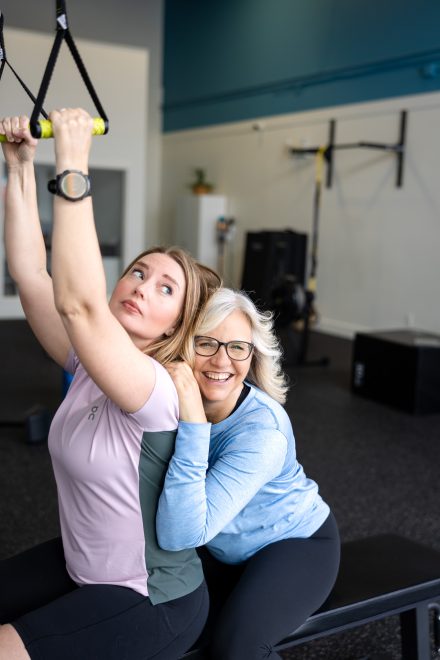 Personal trainer guiding a client through a workout in a cozy home gym setting in the Lower Mainland, emphasizing hands-on expertise.