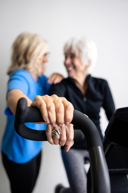 Personal trainer guiding a client through a workout in a cozy home gym setting in the Lower Mainland, emphasizing hands-on expertise.