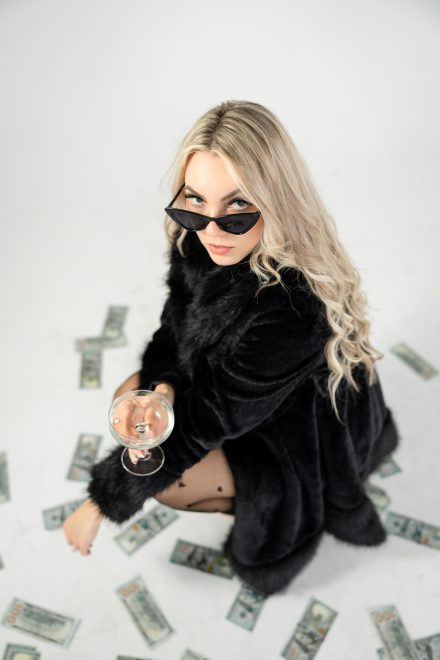 Candid branding photo of Demi sitting on the floor surrounded by marketing materials under dramatic, moody lighting