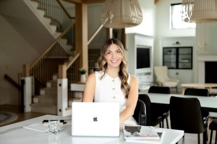 Candid photo of a female real estate agent reviewing property documents on a tablet in a bright living room