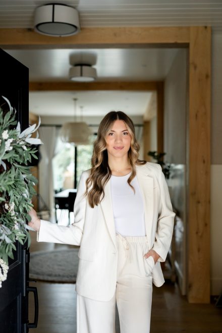 Lifestyle shot of a realtor standing in a spacious entryway, welcoming clients to a Langley property