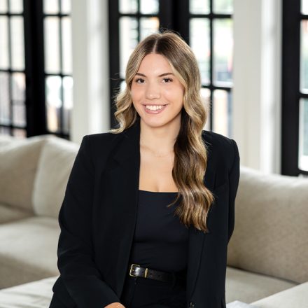 Professional headshot of a female realtor in Langley, BC, smiling in business attire against a blurred office background